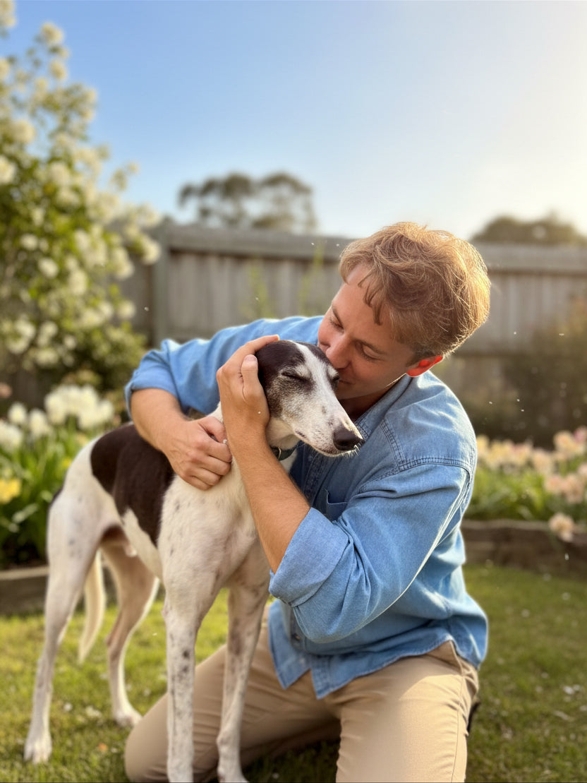 Veterinarian Dr. Feargus McConnell embracing his rescue Greyhound, Ace, in the garden, reflecting the compassion and personal commitment behind Dr. Ferg's dog health education and supplements.
